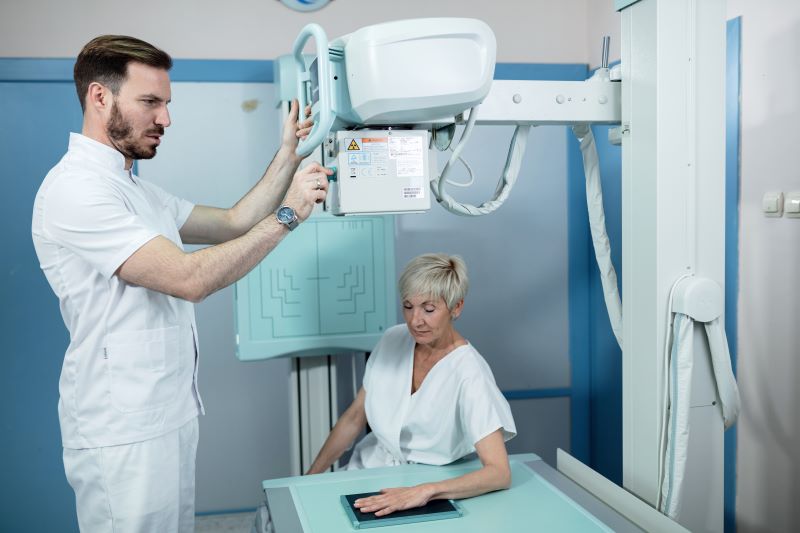 Radiologista fazendo exame de raio-x em paciente.