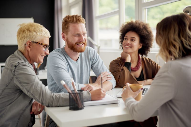 Dimensionamento da CIPA: membros da CIPA reunidos em volta de mesa com computador e caderno.