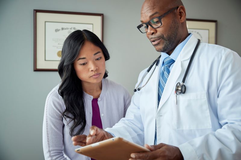 exame demissional é obrigatório​: médico mostrando resultados de exame a trabalhadora
