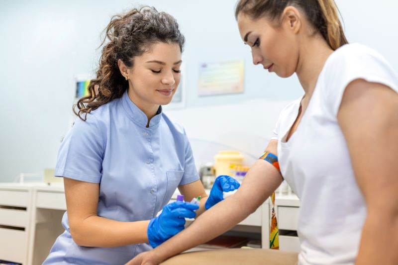 o que reprova no exame de sangue admissional: enfermeira realizando coleta de sangue em mulher