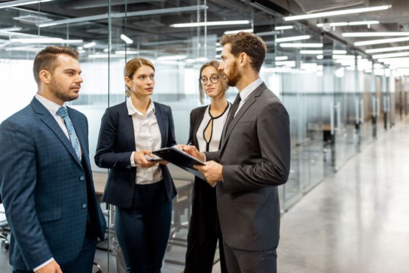 compliance trabalhista​: executivos conversando em corredor de empresa