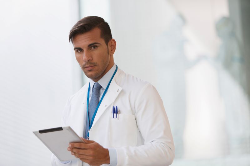 exame de retorno ao trabalho​: médico do trabalho com prancheta na mão